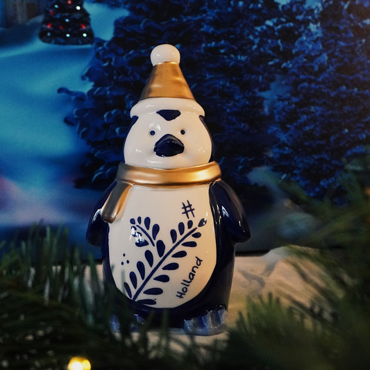 sneeuwpop met holland tekst erop en tulpen in zijn hand handschoenen aan gouden muts van porselein gemaakt breekbaar goed kerstcadeau kerst 2022 delfts blauw kerstmis met keramiek pinguin met goud muts en sjaal